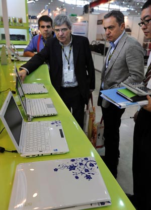 The notebook PCs designed with the style of Qinghuaci, or white porcelain with blue designs, developed by Delux, a Hi-Tech company of China, attract the interest of foreign buyers at COMPUTEX TAIPEI, the world's second largest ICT exhibition, in Taipei of southeast China's Taiwan Province, June 2, 2009. The five-day COMPUTEX TAIPEI was opened on June 2, with the participation of over 1,700 exhibitors. (Xinhua/Wu Ching-teng)