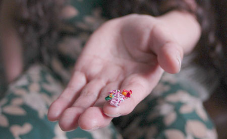 Ren Tingli, the maker of handmade mini shoes craftwork, shows her work in Chifeng city in north China's Inner Mongolia Autonomous Region, June 3, 2009.