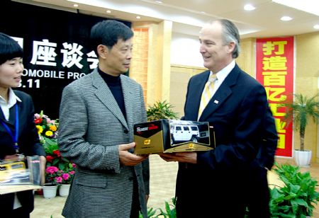 File photo taken on March 11, 2009 shows Hummer CEO James Taylor (R) presenting a Hummer model to a local official in Deyang, southwest China's Sichuan Province. U.S. automaker General Motors Corp., a day after filing Chapter 11 bankruptcy, has a tentative deal to sell its Hummer brand to Chinese-based Sichuan Tengzhong Heavy Industrial Machinery Co., Ltd., the automaker said on June 2.[Xinhua]