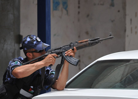 A Palestinian policeman takes position at the scene of the gunbattle in the northern West Bank city of Qalqilya June 4, 2009. (Xinhua/Yin Bogu)