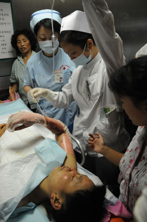 Medical workers treat an injured passenger at the Chengdu No.2 People&apos;s Hospital in Chengdu, capital of southwest China&apos;s Sichuan Province, June 5, 2009. At least 24 people died in a bus blaze Friday morning in Chengdu, said the provincial work safety supervision bureau.