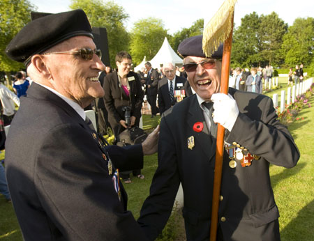 Canadian veteran of the Normandy D-Day invasion Phil Cockburn (L) of London, Ont. greets a French member of a colour guard at the Canadian war cemetery in Beny-sur-Mer June 5, 2009. Hundreds of veterans are gathering in Normandy to remember the 65th anniversary of the D-Day invasion of June 6, 1944.