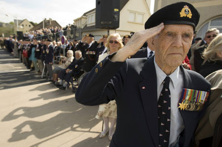 Canadian navy veteran of the Normandy D-Day invasion Harold Tilley of Ottawa stands at attention as national anthems are played during a ceremony on 