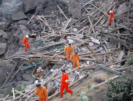  Firemen search for survivors at the site where a landslide occured earlier in the Jiwei Mountain area, in Tiekuang Township, about 170 kilometers southeast of the downtown area, southwest China's Chongqing Municipality, June 5, 2009. At least 80 people were feared buried in the landslide at an iron ore mining area in Chongqing Municipality on Friday, according to the local government.