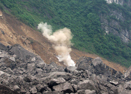 The second blasting is carried out at around 1:00 p.m. to enable the drilling of a hole 40 meters deep to send food and air to 27 trapped miners who could still be alive after Friday's massive landslide in Wulong County of southwest China's Chongqing, June 7, 2009.(Xinhua