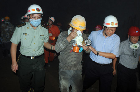 A worker who was trapped in the collapsed tunnel is helped walk out after he is rescued in the Yingbin expressway tunnel near Sanya City in south China's Hainan Province, June 7, 2009. Eight workers who were trapped when a tunnel collapsed Thursday in south China's Hainan Province were rescued after 64 hours on Sunday afternoon. [Hu Jianbing/Xinhua]