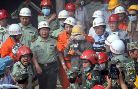 A worker (C) who was trapped in the collapsed tunnel is helped walk out after he is rescued in the Yingbin expressway tunnel near Sanya City in south China's Hainan Province, June 7, 2009. Eight workers who were trapped when a tunnel collapsed Thursday in south China's Hainan Province were rescued after 64 hours on Sunday afternoon. [Zhuang Fei/Xinhua] 