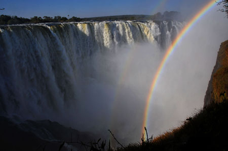 A rainbow appears at the Victoria Falls in the resort town of Victoria Falls in Zimbabwe, June 5, 2009. African largest economic bloc Common Market for Eastern and Southern Africa (COMESA) will hold its annual summit in the Zimbabwean resort town of Victoria Falls on June 7 to 8. [Xu Suhui/Xinhua]