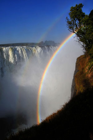 A rainbow appears at the Victoria Falls in the resort town of Victoria Falls in Zimbabwe, June 5, 2009. African largest economic bloc Common Market for Eastern and Southern Africa (COMESA) will hold its annual summit in the Zimbabwean resort town of Victoria Falls on June 7 to 8. [Xu Suhui/Xinhua]