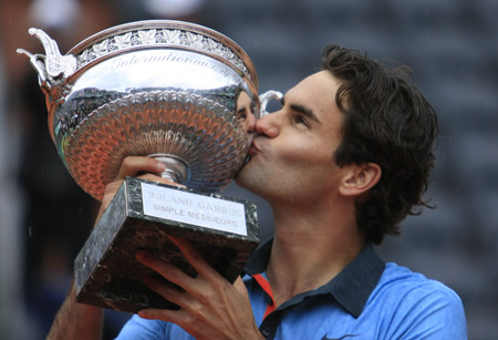 Roger Federer of Switzerland kisses the trophy in the awarding ceremony after winning the men's final against Robin Soderling of Sweden at the French Open tennis tournament at Roland Garros in Paris on June 7, 2009. [Xinhua]