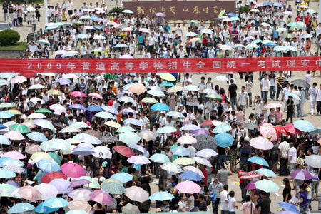 Chinese students and their family members walk home after they finished the first day tests of the National College Entrance Examination, which will last until Tuesday for 