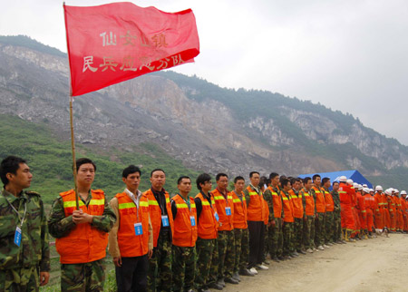 Local militia and firemen stand on the alert prior to the second blasting in Wulong County of southwest China's Chongqing, June 7, 2009. The second blasting was carried out at around 1:00 p.m. Sunday to enable the drilling of a hole 40 meters deep to send food and air to 27 trapped miners who could still be alive after Friday's massive landslide.[Xinhua]