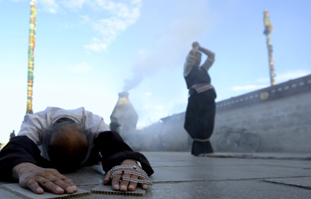 A faithful prays in Lhasa, southwest China's Tibet Autonomous Region, while celebrating the peak day of the Sakadawa Festival, June 7, 2009. [Purbu Zhaxi/Xinhua]