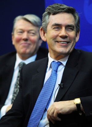 Britain's Prime Minister Gordon Brown (R), flanked by Health Secretary Alan Johnson, smiles before giving his speech on the National Health Service at King's College in London January 7, 2008.