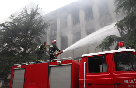 Chinese fire fighters put out a fire which engulfs the science and technology hall of the Bengbu Science Palace in Bengbu city in east China's Anhui province, June 8, 2009. An employee on duty were killed in the early morning fire and the cause is under investigation.(Xinhua Photo)
