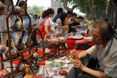 A folk handicraftsman extemporizes the craftwork, during the Traditional Chinese Folk Stunts Show, on the Xijindu Ancient Street of Zhenjiang City, east China's Jiangsu Province, June 7, 2009. [Chen Gang/Xinhua]