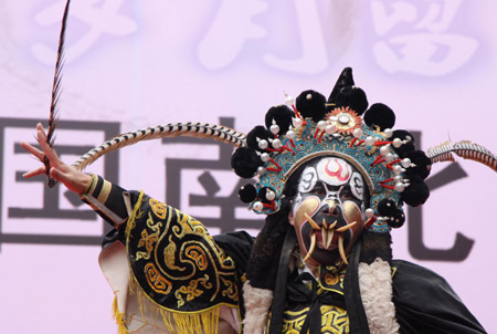 An opera actor display the theatrical skill of dallying with teeth, during the Traditional Chinese Folk Stunts Show, on the Xijindu Ancient Street of Zhenjiang City, east China's Jiangsu Province, June 7, 2009. [Tao Chun/Xinhua]