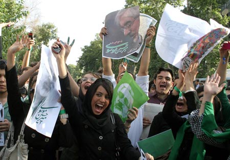 Supporters of Iranian presidential hopeful Mir Hossein Mousavi, former Prime Minister, jubilate while holding posters of Mousavi during a presidential election campaign in Teheran, capital of Iran, June 8, 2009. Thousands of backers of Mousavi formed a human chain here on Monday to support him in the presidential elections on June 12. [Ahmad Halabisaz/Xinhua]