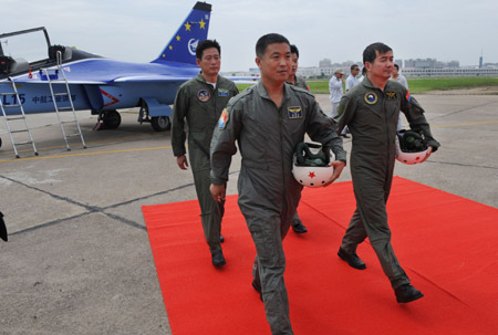 Pilots Yang Yao (R front) and Guo Yanbo (L front) of the L15-05 trainer plane, developed by the Hongdu Aviation Industry Group, walks out of the plane after it flew back to Qingyunpu airport in Nanchang, east China's Jiangxi Province, June 8, 2009. [Song Zhenping/Xinhua]