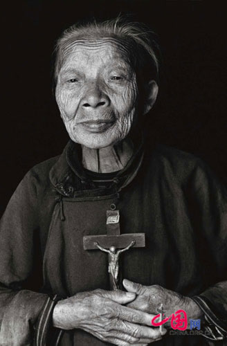In the river of life, belief is the only thing people can rely on and pass on. A pious old lady is holding a Chirist cross. Zhouzhi county, June, 1998