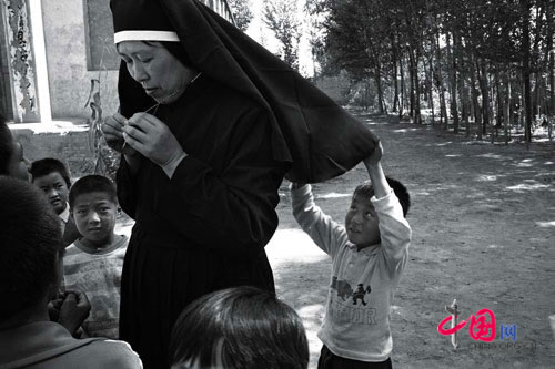A child peers under a nun's wimple, Oct. 1998