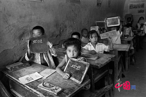Students are having classes in cave-house and writing on stone plate, Suide county, Shaanxi, Sept 1991.