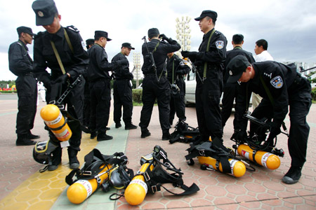 Members of the special police put on gas masks during an anti-terrorism drill in Hohhot, capital of north China's Inner Mongolia Autonomous Region, June 9, 2009. (Xinhua/Zheng Huansong)