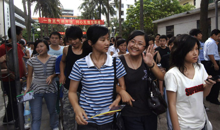 Students walk out after finishing their college entrance exam at the Haikou No.1 Middle School in Haikou, capital of south China's Hainan Province, June 9, 2009. The national college entrance examination, or 'gaokao' in Chinese, was finished in most regions of China on June 8. Students in Shanghai and Shandong finished the exam at noon of June 9 and students in Jiangsu, Guangdong and Hainan finished it in the afternoon. [Zhao Yingquan/Xinhua]