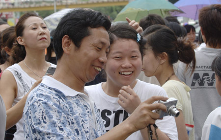A student and her relative share a light moment after finishing the college entrance exam at a middle school in Haikou, capital of south China's Hainan Province, June 9, 2009. [Zhao Yingquan/Xinhua]