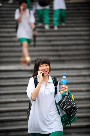 A student walks out after finishing her college entrance exam at a middle school in Guangzhou, capital of south China's Guangdong Province, June 9, 2009. [Chen Yehua/Xinhua]