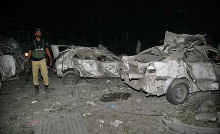 A policeman stands near destroyed vehicles at the site off a bomb attack in a hotel in Peshawar June 9, 2009. At least 11 people were killed and 50 others were injured Tuesday evening when a blast hit a five-star hotel in the northwestern Pakistani city of Peshawar, according to local TV reports. [Xinhua/Reuters]