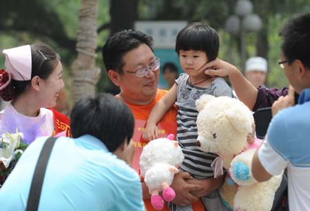 The first confirmed A/H1N1 flu patient in Henan Province (R1) prepares to leave the hospital in Zhengzhou, capital of central China's Henan Province, on June 9, 2009. The 3-year-old girl was discharged from hospital on Tuesday. She arrived in Zhengzhou on May 29 from the United States and was confirmed as the first A/H1N1 case in Henan on June 1.[Xinhua] 