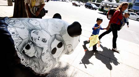 A woman walks past a panda-shaped sculpture with her child during a culture festival in Mexico City, capital of Mexico, on June 8, 2009. A cultural festival was held here until June 14 by local government to revitalize the tourism in the city. [Bao Feifei/Xinhua]