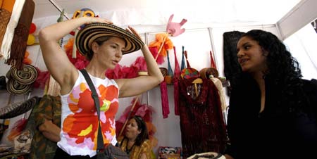  A woman tries on a Mexican hat during a culture festival in Mexico City, capital of Mexico, on June 8, 2009. A cultural festival was held here until June 14 by local government to revitalize the tourism in the city. [Bao Feifei/Xinhua]