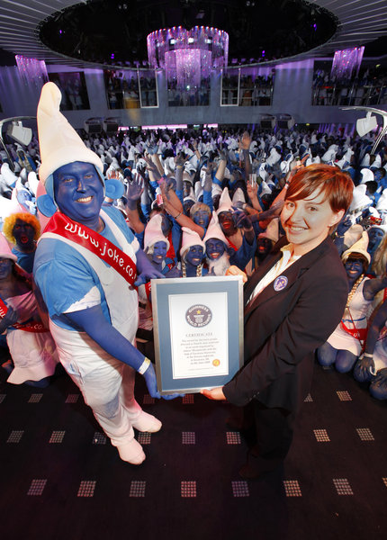 Guiness adjudicator Laura Farmer hands over the official Guiness World Record certificate to Mark Lewis, Founder and MD of Jokers' Masquerade, after 2510 people broke the world record for the most people dressed as smurfs, at Oceana nightclub in Swansea, on the 8th of June 2009. 