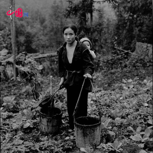 Zhou Tingyan, 20, has a family of 4 and 1.5 acres of land. She harvests 500 kilograms of grain every year and borrows money to buy a calf and 4 pigs, Menghou village, Yunnan, Nov, 2001