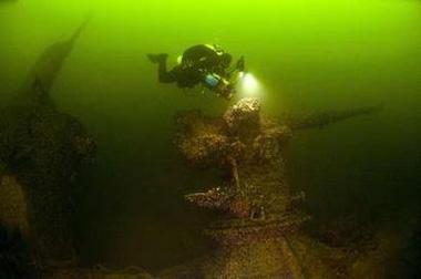 A diver examines the deck gun of a Soviet submarine that was sunk during Finland's Winter War in 1940 in this handout photo made available June 9, 2009. [Stefan Hogeborn/Scanpix/CCTV/REUTERS]