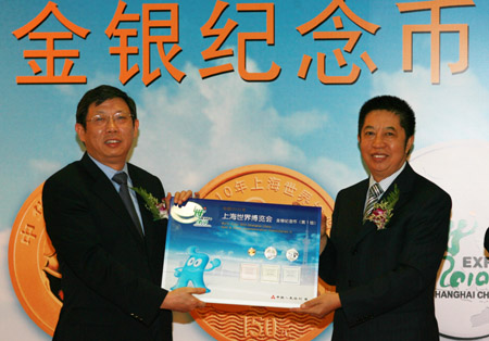 Ma Delun (left), the deputy governor of the People's Bank of China, presents gold and silver coins to the 2010 World Expo on behalf of the bank on Wednesday, June 10, 2009. [Photo: Xinhuanet.com]