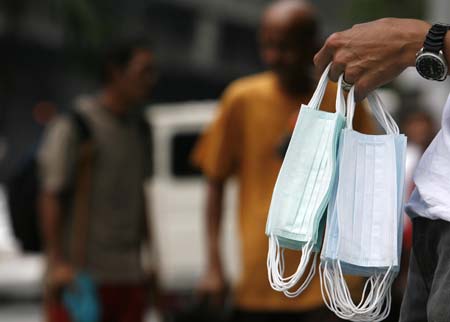 A vendor sells face masks on a busy street in Manila June 11, 2009. Health Secretary Francisco Duque III said on Thursday, 15 new cases of new flu virus were confirmed bringing the total number of Influenza A(H1N1) cases to 92, the highest number in southeast Asia. [Xinhua/Reuters]