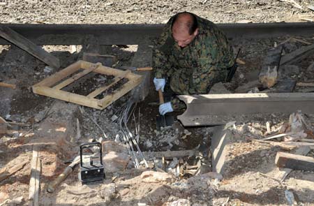 A serviceman from Georgia's interior ministry inspects the site of an explosion at a railway station in Zugdidi June 11, 2009. Three explosions within three hours hit a town in western Georgia overnight near the breakaway region of Abkhazia, injuring one person, the Interior Ministry said on Thursday.[Xinhua/Reuters]