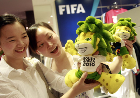 Two Chinese girls admire the mascot of the 2010 FIFA World Cup South Africa Zakumi inside the first souvenir shop officially authorized by FIFA in China, at a downtown shopping mall in Shanghai, China, June 11, 2009.[Xinhua]