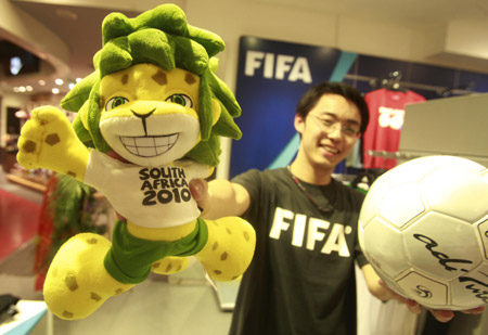 A Chinese salesman shows off the mascot of the 2010 FIFA World Cup South Africa Zakumi inside the first souvenir shop officially authorized by FIFA in China, at a downtown shopping mall in Shanghai, China, June 11, 2009.[Xinhua]