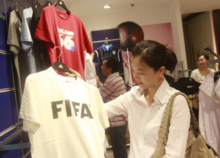 Chinese customers select T-shirts inside the first souvenir shop officially authorized by FIFA in China for the 2010 FIFA World Cup South Africa, at a downtown shopping mall in Shanghai, China, June 11, 2009.[Xinhua]