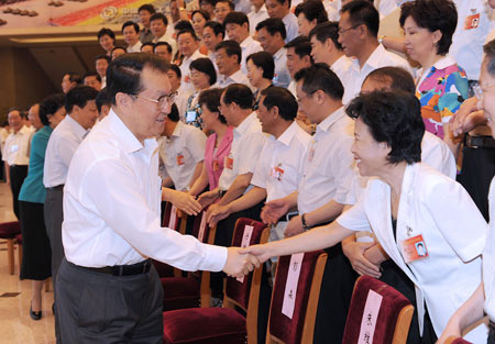 Li Changchun (L, front), member of the Standing Committee of the Political Bureau of the Communist Party of China (CPC) Central Committee, meets with the delegates of a national work conference on ethnic culture, in Beijing, capital of China, June 12, 2009. 