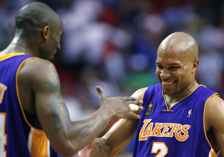 Los Angeles Lakers Derek Fisher (R) shakes hands with teammate Kobe Bryant after Fisher hit a three-point shot in overtime during Game 4 of their NBA Finals basketball game against the Orlando Magic in Orlando, Florida, June 11, 2009. [Agencies] 