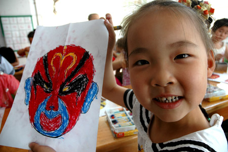 A Chinese kid shows off her drawing of a Peking Opera facial make-up at a kindergarten in Jiyuan City of central China's Henan Province, June 12, 2009, during a campaign marking the fourth Cultural Heritage Day of China, which falls on June 13 this year. 