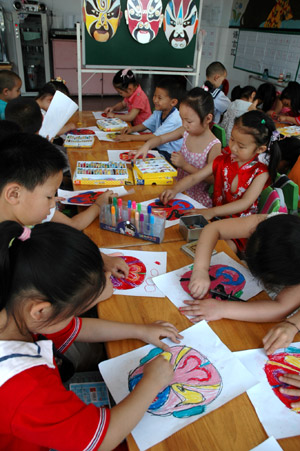 Chinese kids draw Peking Opera facial make-ups at a kindergarten in Jiyuan City of central China's Henan Province, June 12, 2009, during a campaign marking the fourth Cultural Heritage Day of China, which falls on June 13 this year.(