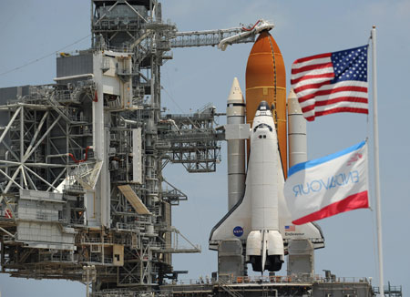 The U.S. and Endeavour orbiter flags wave in the breeze in front of the space shuttle Endeavour Friday afternoon June 12, 2009 at the Kennedy Space Center in Cape Canaveral, Florida.(Xinhua/AFP Photo)