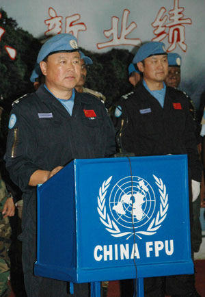 Zhang Daning (L), commissar of China's 7th riot police squad to Haiti on a peacekeeping mission for the United Nations, holds a ceremony to welcome China's 8th riot police squad to Haiti in Port-au-Prince, June 13, 2009. [Yin Nan/Xinhua]
