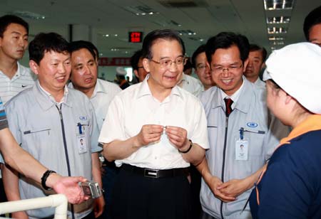 Chinese Premier Wen Jiabao (C), also a member of the Standing Committee of the Political Bureau of the Communist Party of China (CPC) Central Committee, talks with employees of Aiming Digital Electrical Co.,Ltd in central China's Hunan Province, on June 13, 2009. Premier Wen made an inspection tour in Hunan Province from June 12 to June 14. [Xinhua]